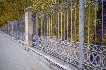 Old iron park fence on an autumn day