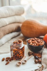 Jar with craft sweet honey and nuts in autumn interior