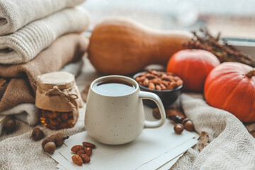 Fototapeta na wymiar Cup of tea and almonds in autumn decor, good morning concept