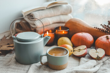 Fototapeta na wymiar Teapot and cup with sea buckthorn tea, autumn mood