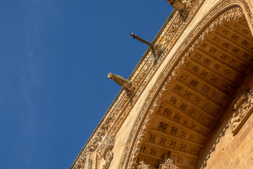 View from below of the ornaments of the arch and the cornice of the main door with bas-reliefs of...