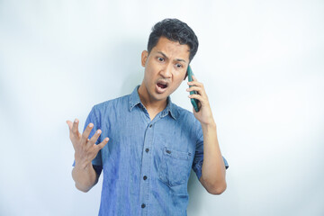 Portrait of angry young Asian business man serious frustrated getting angry argue while talking on mobile phone, communication conversation isolated on white background