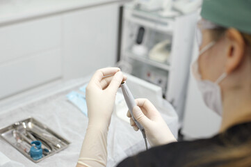 hands of doctor hold key nozzle and piezoelectric scaler removal of dental deposits cleaning implants tissue preparation ultrasonic scaler harmonious combination of modern technologies and power