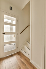 the inside of a house with wood flooring and white walls, an open door leading to a patio area