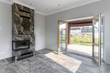 View of the large living room with fireplace immediately after renovation