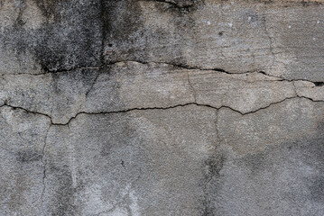 Old gray concrete wall with cracks and black stains.