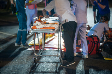 Paramedics are preparing stretcher for accident patients at night.