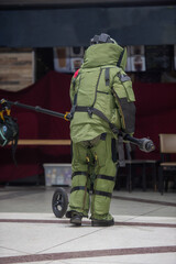 Bomb disposal officers wearing protective gear Investigating a suspected bomb in the airport building. with remote robotic arm
