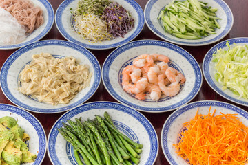Prawns, raw vegetables and tofu on chinese plates