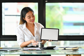 Confident businesswoman showing digital tablet with empty screen for advertising or text message