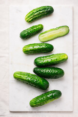 Fresh organic cucumbers on marble tray.