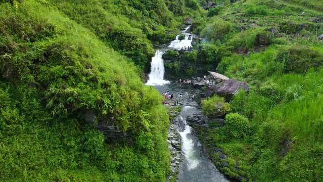Tourists and visitors enjoying the flowing water of the Du Gia Waterfall, Vietnam