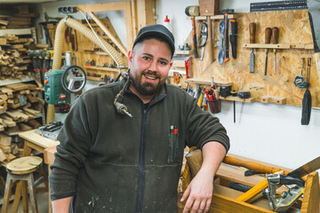 Portrait of caucasian male joiner standing at workbench inside his carpentry workshop. High quality photo