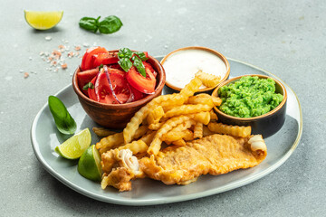 Fish and chips with green peas, vegetable salad, tartar sauce, British cuisine concept