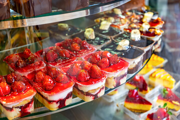 Assorted delicious fruit desserts, cakes and biscuits on shopwindow in caffee. Sweets and treats, tasty food, bakery, pastry. Coffee shop, bakery, small business concept.