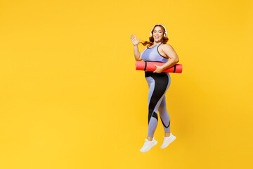 Fototapeta na wymiar Full body young chubby plus size big fat fit woman wear blue top warm up training hold yoga mat listen to music in headphones isolated on plain yellow background studio home gym Workout sport concept