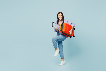 Traveler woman wear casual clothes hold suitcase bag pov play guitar isolated on plain pastel blue...