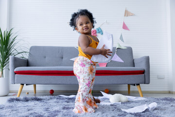 A cute curly hair girl  toddler's naughty play inside the living room.