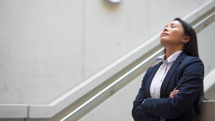 Woman taking relaxing break in modern building's staircase