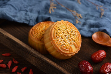 The Mid-Autumn Festival moon cake on the retro background. The Chinese meaning of the moon cake in the picture is: fine five kernels, black sesame, representing the taste of mooncakes