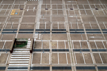 Parcheggio automobili in città, ripreso dall'alto. Linee geometria di strisce bianche su pavimento.