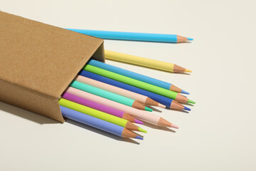 Colored, wooden pencils in a craft box on a light background.