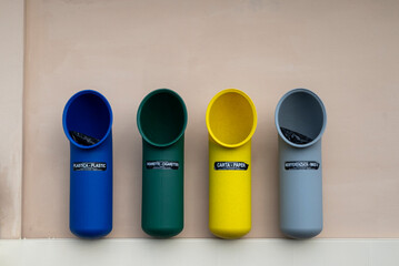 Quattro cestini per rifiuti differenziata: Plastica, sigarette, carta, non riciclabile.
