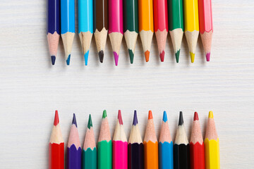 Colored wooden pencils on a light background.