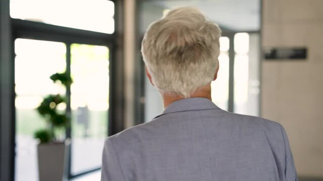 Experienced executive striding confidently through corporate corridor
