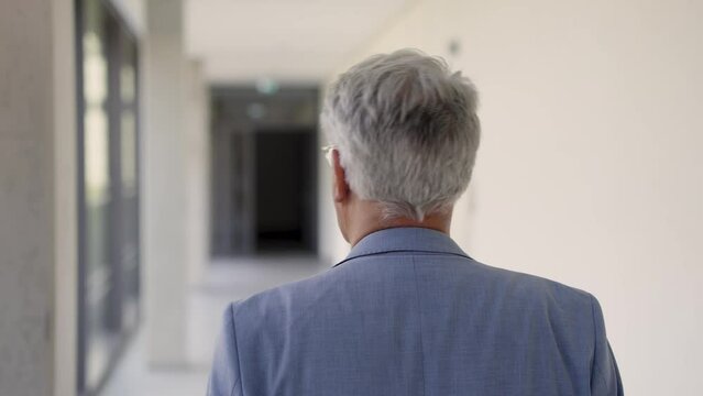 Experienced executive striding confidently through corporate corridor