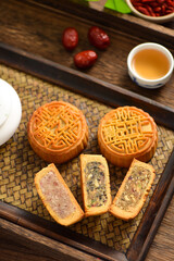The Mid-Autumn Festival moon cake on the retro background. The Chinese meaning of the moon cake in the picture is: fine five kernels, black sesame, representing the taste of mooncakes
