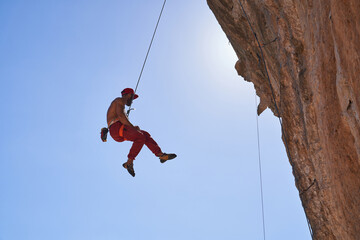 Strong climber hanging on rope