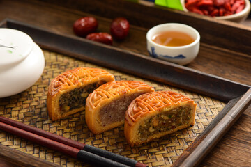 Mid-Autumn Festival mooncakes on a retro background. The Chinese meaning on the mooncakes in the picture is: fine five kernels, black sesame, rock sugar roses, representing the taste of mooncakes