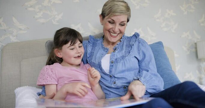 Mother and daughter reading together picture book