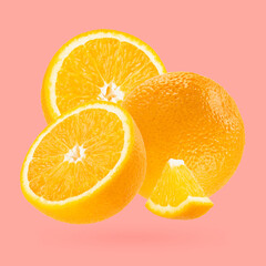 Bright oranges closeup levitation as art composition. Whole, half, piece fruits on pastel pink background with shadow. Tropical fruits for advertising, design, label product, poster, card.