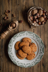 Homemade rustic biscuits. Some ingredients are: eggs; sugar; flour; butter, nuts, hazelnuts, and chocolate, on wooden table. Top View.