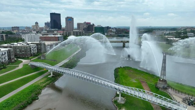 Five Rivers Fountain of Lights in Dayton, Ohio. Water feature at conjunction of Mad River and Miami River. Aerial rising shot revealing Dayton, OH skyline in summer.