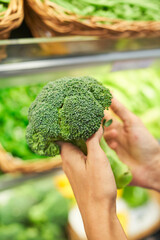 Fresh broccoli in hands of customer