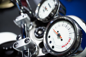 Side view of a black dial showing the speed of a vintage motorcycle