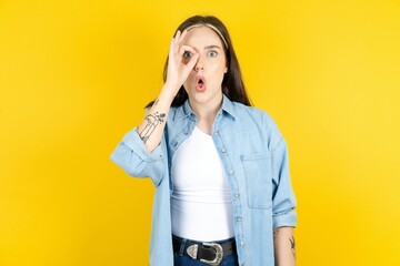 Beautiful woman wearing casual clothes doing ok gesture shocked with surprised face, eye looking...