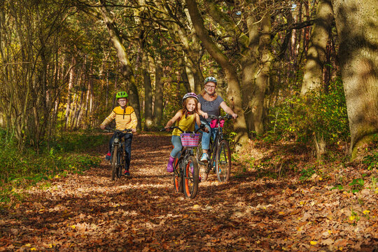 Young family with son and little daughter at bicycles, in the middle of autumn nature.