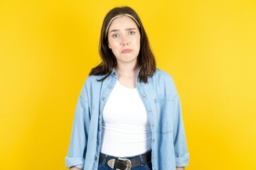 Displeased upset Beautiful woman wearing casual clothes frowns face as going to cry, being discontent and unhappy as can't achieve goals,  Disappointed model has troubles - obrazy, fototapety, plakaty
