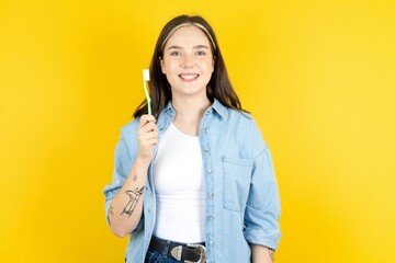 Beautiful woman wearing casual clothes holding a toothbrush and smiling. Dental healthcare concept.