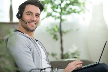 handsome man wearing headset and using a laptop