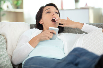 attractive woman holding smartphone and yawning