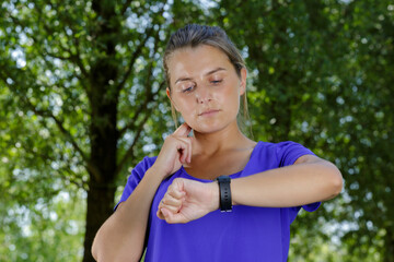 Fototapeta premium young woman checking her pulse outdoors after running