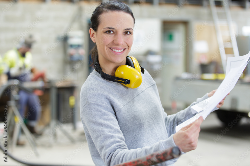 Wall mural happy female metalworker meeting in factory