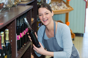 happy female wine seller in supermarket