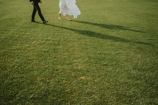 bride and groom walking in the park