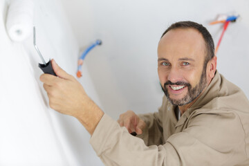 professional male decorator using paint roller